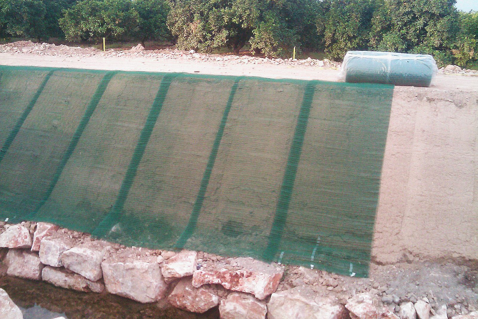 Géotextile ancré sur un talus en bord de cours d'eau pour limiter le ruissellement